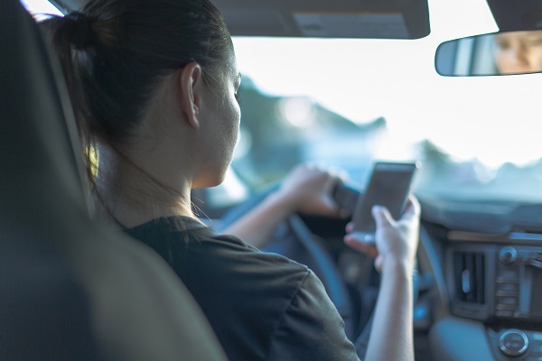 Driving and texting in car with blue tone